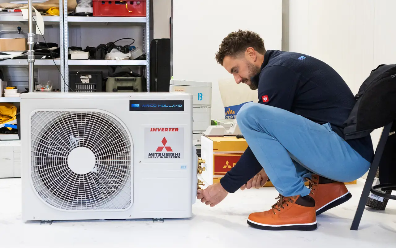 Rein werkt aan de aansluitkant van een buitenunit van Mitsubishi Heavy Industries.