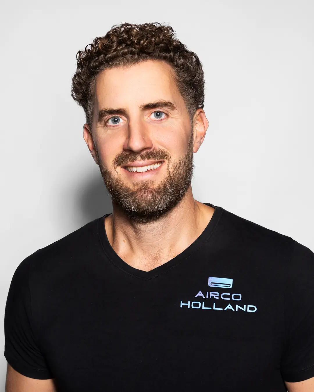 Rein van Airco Holland lacht in de camera, in een zwart shirt met het logo.